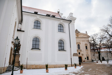 Strahov Monastery with White Baroque church, Premonstratensian abbey in Bohemia under snow, Basilica of the Assumption of Virgin Mary in winter day, Hradcany, Prague, Czech Republic