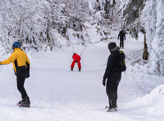 People enjoying skiing and snowboarding on the Clabucet ski lope in Predeal Mountain resort in...