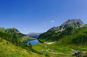 Naklejka na ściany i meble gorgeous green mountain landscape with a deep blue lake panorama