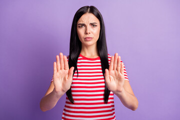 Photo of unhappy stressed young girl raise palms show stop sign wear striped red shirt isolated violet color background