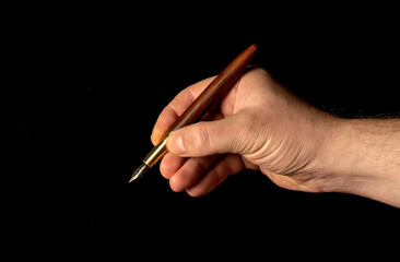 Close-up male hand writing with a pen,  pen in hand, isolated on black background. File contains with clipping path So easy to work