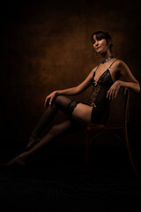 Sexy woman posing in black lace lingerie. The boudoir fantasy image of a sensual beautiful lady has returned to erotic underwear. Hot female model in fishnet stockings.