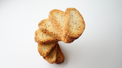 Small crunchy croutons with poppy seeds on a white table surface