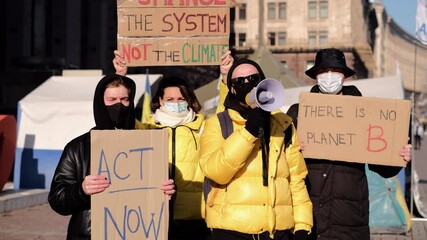 A group of people with banners and a megaphone in hand are protesting in the city square for save planet clean world act now  