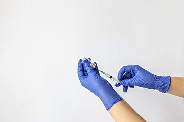 A medical worker in medical gloves draws a dose of coronavirus vaccine into a syringe. The concept of vaccination, immunization, prevention of people from Covid-19