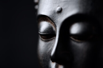 Meditating Buddha Statue isolated on black background. Copy space.	