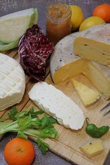 cheese boards, vegetables and quince mustard, white fresh cheese and yellow long-ripening cheese, cheese with pepper, table set with cheese