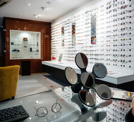 Interior of modern optician store with large selection of eyewear with floral shaped mirror on...