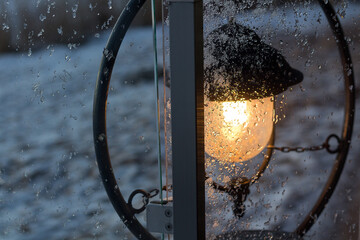 A burning lantern behind the frozen glass