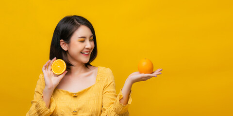 Isolated Asian girl smiling with holding orange fruit.