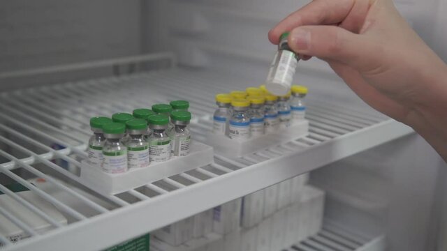 Nurse receiving covid 19 vaccine from vaccine locker. Covid 19 vaccine. close-up