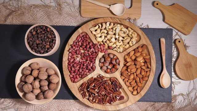 selection of nuts peanuts, hazelnuts, almonds, cashews, walnuts, pecans on a wooden table. Top view with space for your text