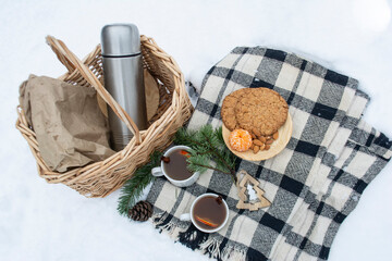 Fototapeta na wymiar Winter picnic in the forest. Picnic basket in the snow. Winter holidays