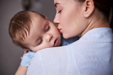 Portrait of tender woman kissing her child