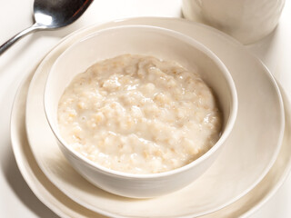 Oatmeal porridge in a white porcelain bowl