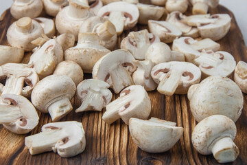 Close-up of whole and sliced mushrooms lying on a dark wooden board