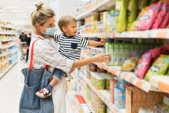 Mother and her little son in a supermarket during virus pandemic