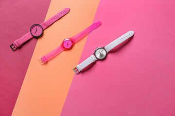 Stylish wrist watches on colorful background