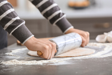 Woman making dough in kitchen