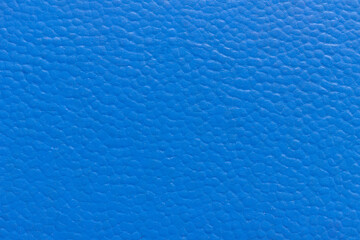 The surface of the blue old worn dermatin with a small pattern.