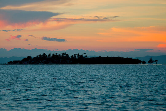 Dramatic orange tinged Sunset in the Bohol Strait. Silhoutte of Hambongan Island, a small inhabited islet off the town of Clarin.