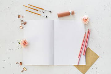 Composition with blank magazine, perfume and stationary on light background