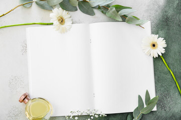 Blank magazine, perfume and flowers on color background