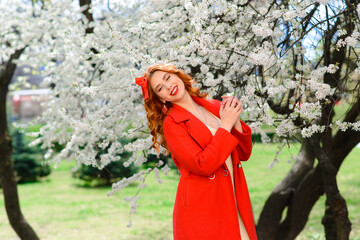 Spring beauty female with long red blowing hair outdoors. Romantic young woman portrait.