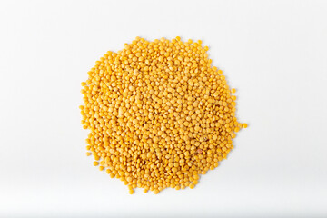 Pile of yellow lentils on white background.