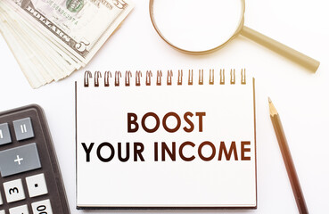 BOOST YOUR INCOME - text written on a notebook with office background.
