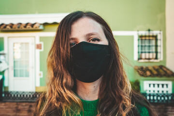 Image of a woman in red with a black face mask