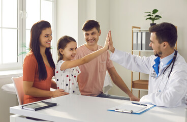 Mom, dad and child seeing family practitioner. Happy girl high-fiving her pediatrician. Concept of...