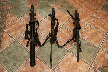 A rifle with sights on a floor background. Modern optical and collimator sight.
