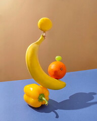 Fresh yellow fruits and vegetables on a blue table. Equilibrium floating food