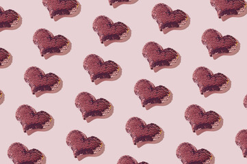 Trendy pattern made from sequin hearts on pink background. Love, romantic or Valentine's day concept