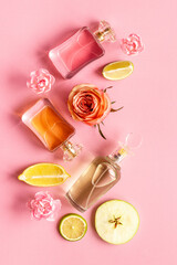 Perfume bottles with flowers and fruits, top view