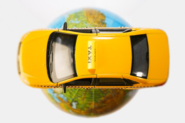 globe on the roof of yellow taxi car - plastic toy model   isolated on white  background. empty...