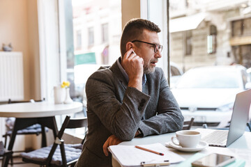 Handsome confident businessman working on laptop