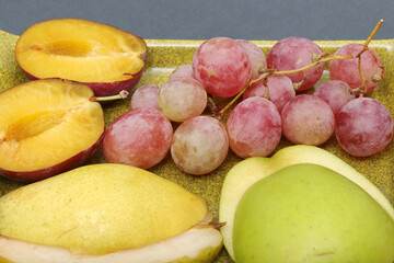 fresh fruits grape, plum, apple, pear in the plate