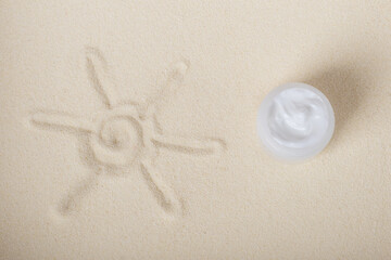 Bottle of sun block creme on sand