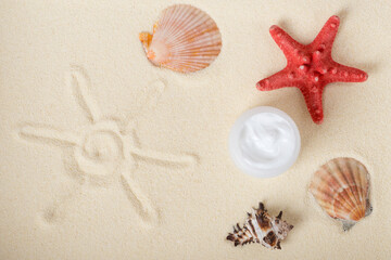 Fototapeta na wymiar Bottle of sunblock with shells on sand