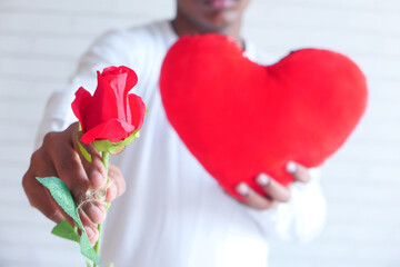  unrecognized man hand holding rose flower and gift box close up 