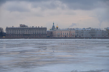 Obraz premium View of the frozen Neva River and the embankment in the historical center of St. Petersburg in Russia on a cloudy winter day