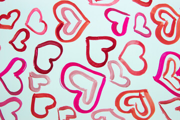 Pattern from colored painted hearts, background from watercolor paints