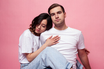 Fototapeta premium young cheerful caucasian couple together having fun on pink background, guy ang girl modern relationship, lifestyle people concept