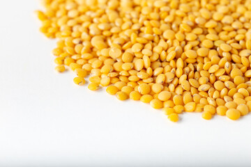 Pile of yellow lentil on white background.