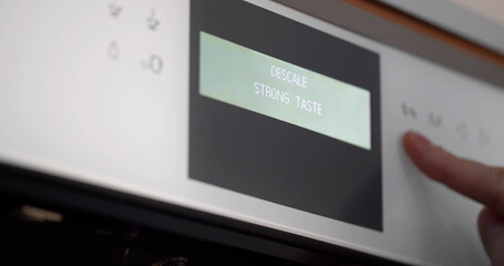 Close up of hand setting program on automatic coffee machine panel