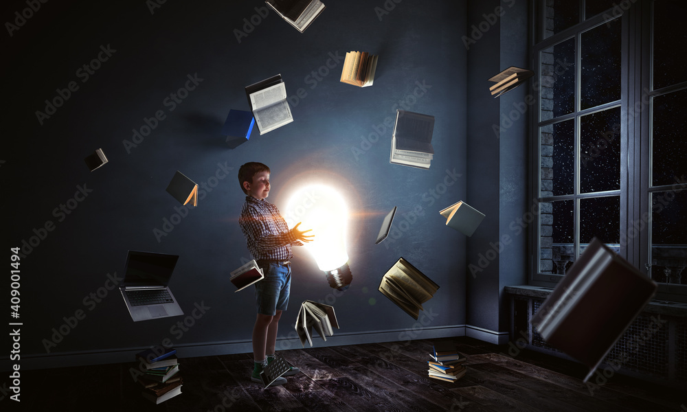 Wall mural boy holding a light bulb with books around him