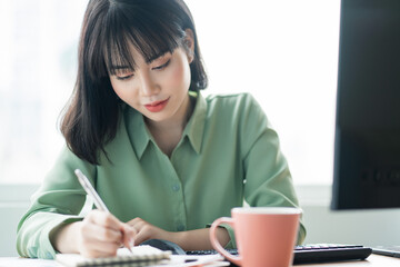 Beautiful Asian businesswoman working intently at the office