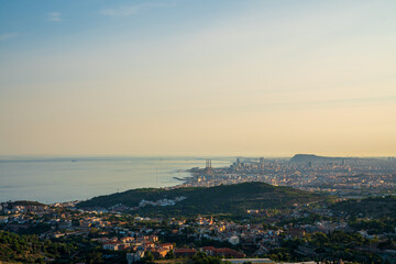 Panoramic view of the entire city of Barcelona and its surroundings. During sunset one day in late summer. We can see the Mediterranean sea completely flat.